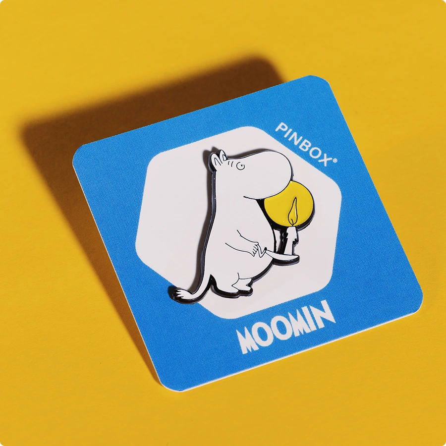 Emaliowany pin Muminek ze świecą to wyjątkowa przypinka inspirowana światem Muminków, przedstawiająca uroczą postać trzymającą zapaloną świecę.
Pin przypięty do niebieskiej karteczki